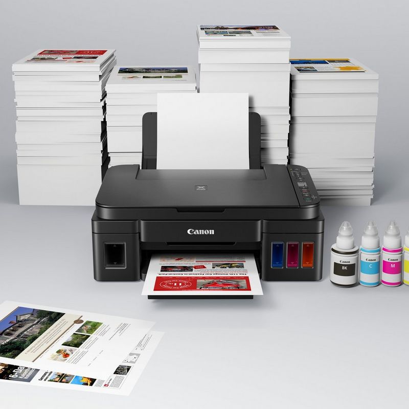 Canon PIXMA G3510 Drucker Auf einem Tisch zusammen mit den Tintenflaschen