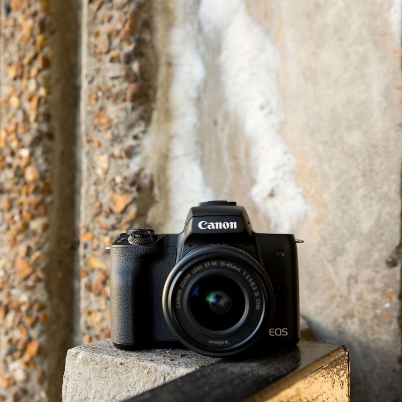 Canon EOS M50 Schwarz + EF-M 15-45mm IS STM Objektiv Schwarz 0 Die Kamera neben einem Gebäude