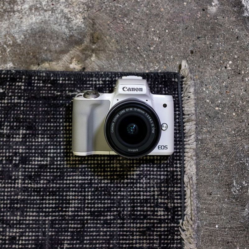 Canon EOS M50 Weiß + EF-M 15-45mm IS STM Objektiv Silber 0 Die Kamera auf einem Teppich