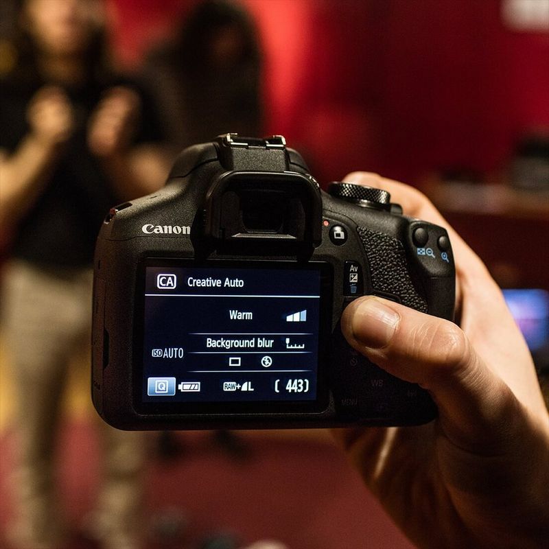 Canon EOS 2000D + EF-S 18-55mm IS II Objektiv + Rucksack + SD-Karte Rückansicht in Verwendung