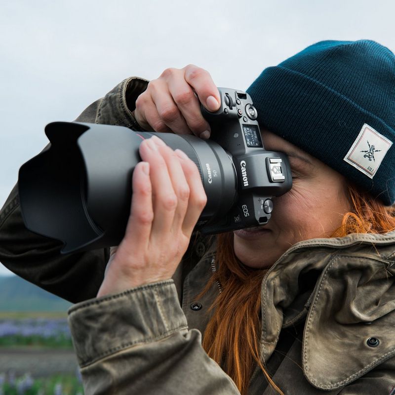 Canon RF 50mm F1.2L USM Objektiv Eine Frau, die eine Kamera vor ihr Gesicht hält