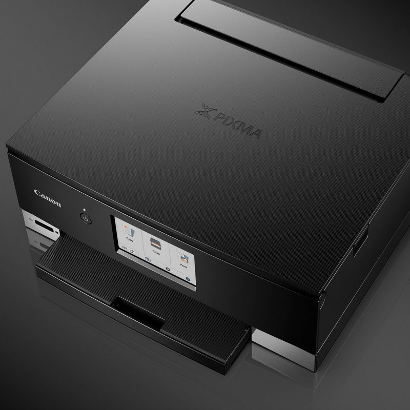 Canon PIXMA TS8250 Multifunktionssystem, Schwarz Produkt Schrägansicht von vorne mit einer Person, die die Druckausgabe prüft