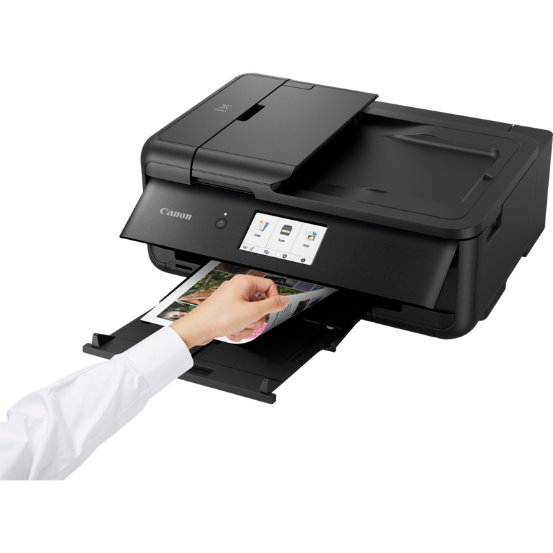 Canon PIXMA TS9550 Tintenstrahl-Multifunktionssystem, Schwarz Produkt Schrägansicht von vorne mit einer Person, die die Druckausgabe prüft