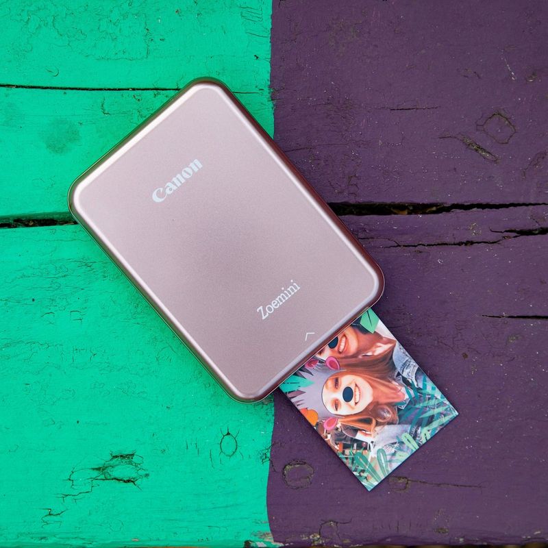 Canon Zoemini mobiler Fotodrucker, Rose Gold Drucker mit Ausdruck auf einem bunten Schreibtisch