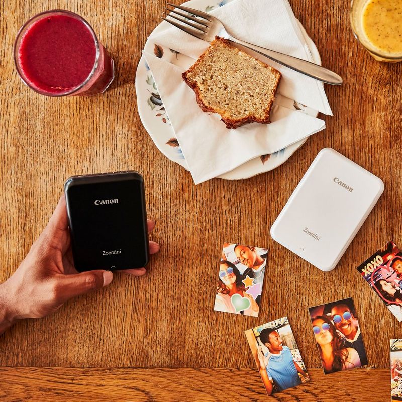 Canon Zoemini mobiler Fotodrucker, Weiß Drucker in einer Hand auf einem Schreibtisch