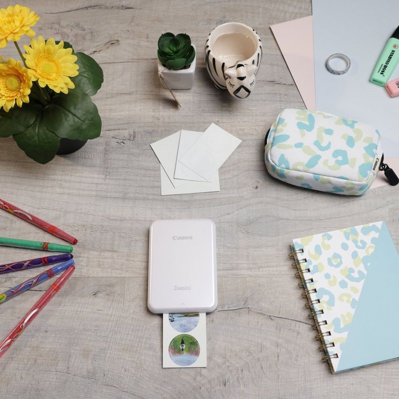 Canon Zoemini Mini-Fotodrucker, weiß + Tagebuch + Tasche Drucker auf einem Schreibtisch mit Stiften