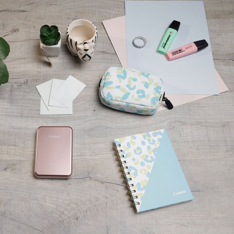 Canon Zoemini Mini-Fotodrucker, Roségold + Tagebuch + Tasche Drucker auf einem Schreibtisch mit Tasse