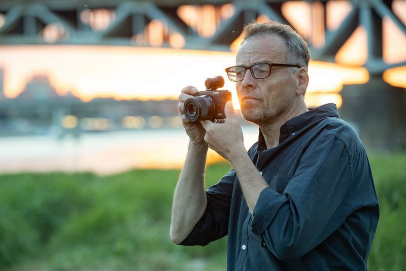 Canon EOS M6 Mark II + EF-M 15-45mm IS STM Objektiv + Elektronischer Sucher 0 Ein Mann, der die Kamera vor sein Gesicht hält