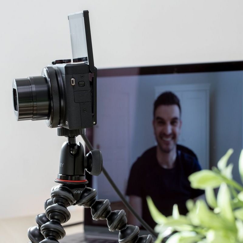 Canon PowerShot G7 X Mark III kompaktes Videokonferenz-Kit Kamera, die auf einem Stativ befestigt ist und über ein Kabel mit einem Laptop verbunden ist