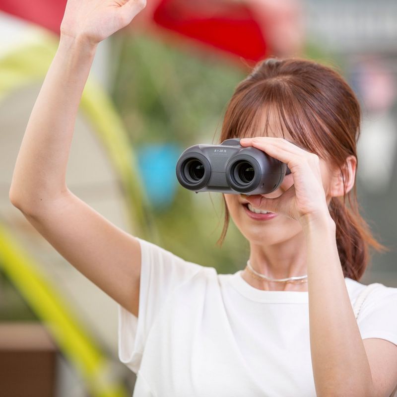 Canon 8x20 IS Fernglas Frau, die das Fernglas im Freien verwendet