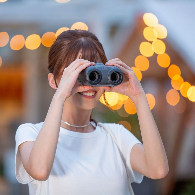 Canon 8x20 IS Fernglas Frau, die das Fernglas im Freien verwendet