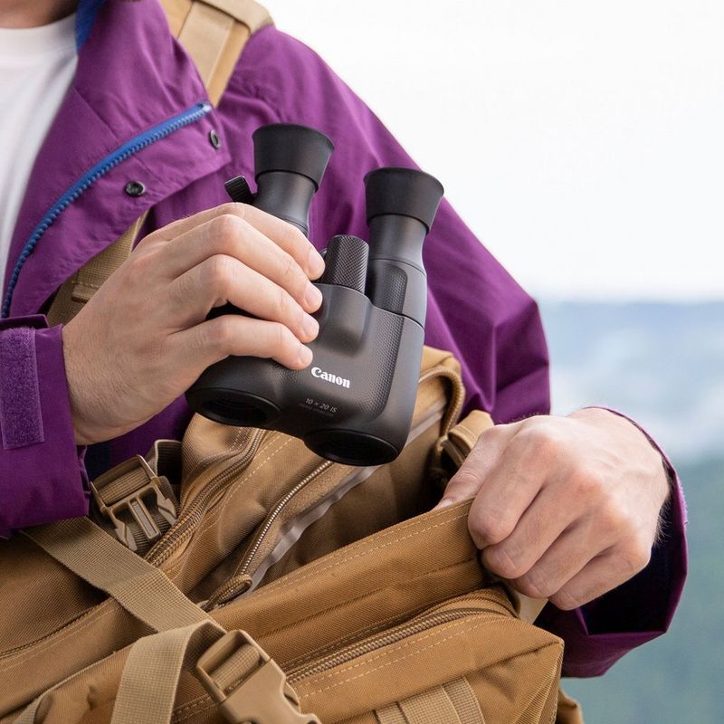 Canon 10x20 IS Fernglas Mann, der das Fernglas hält, um es in seiner Schultertasche zu verstauen