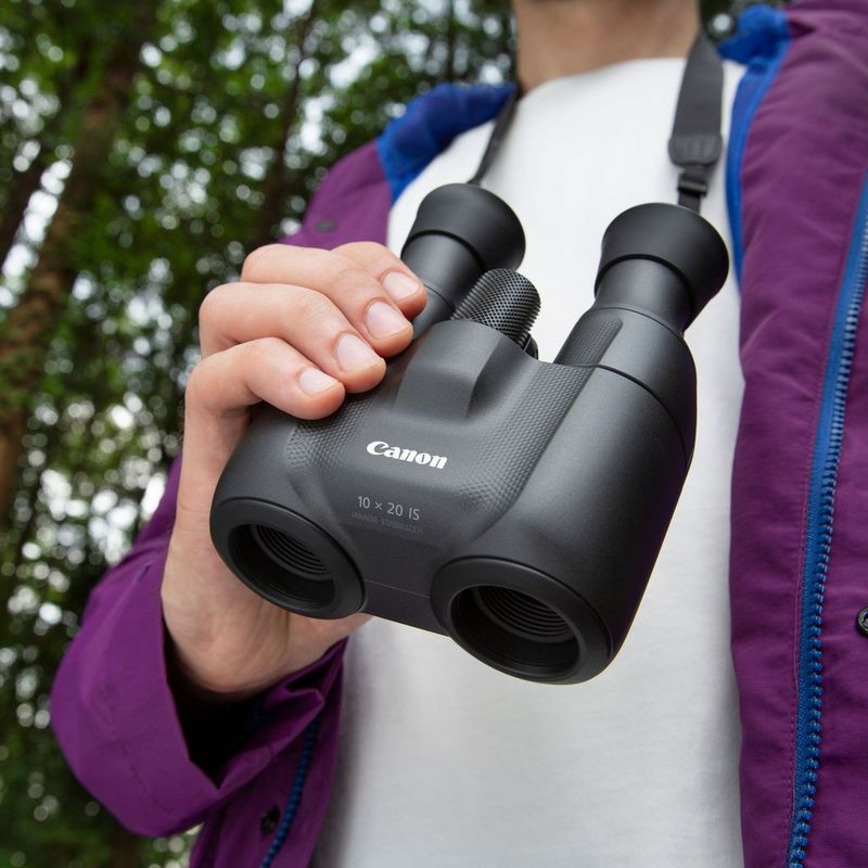 Canon 10x20 IS Fernglas Mann, der ein Fernglas in der Hand hält