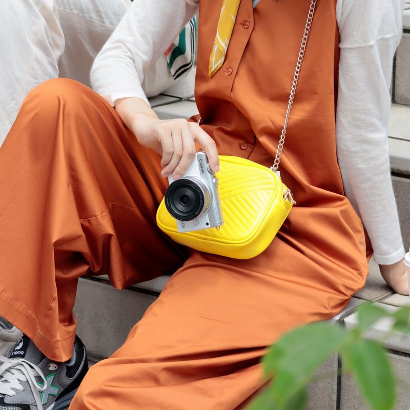 Canon EOS M200 Gehäuse, Weiß + EF-M 15-45mm, Silber 0 Eine Frau, die die Kamera hält