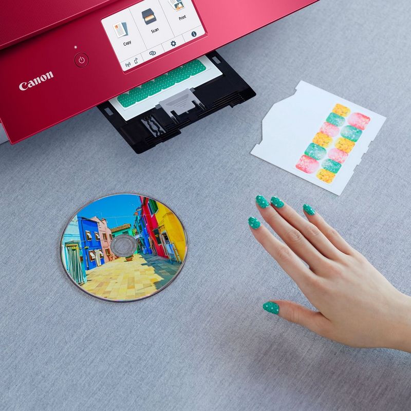 Canon PIXMA TS8352 Tintenstrahl-Multifunktionssystem, Rot Produkt Vorderansicht mit einer Person, die versucht, das Foto zu entnehmen