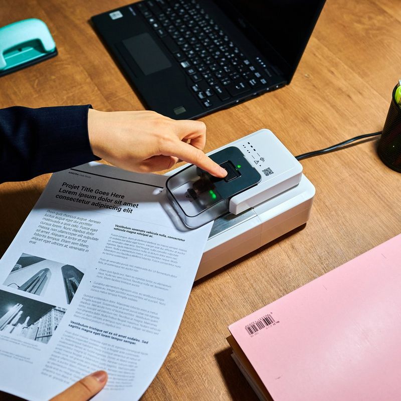 Automatischer Heftklammerentferner A1 0 Hand, die das Produkt neben einem Laptop verwendet