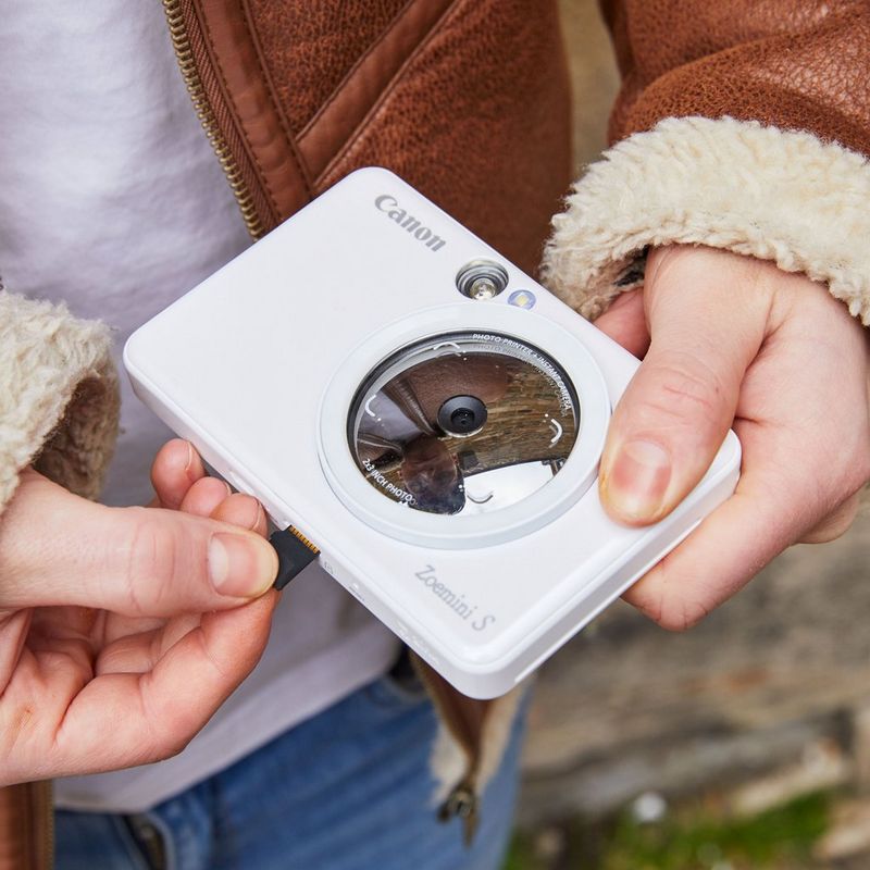 Canon Zoemini S Sofortbildkamera und Mini-Fotodrucker, Perlweiß Hände, die einen Speicherstick in den Drucker einsetzen
