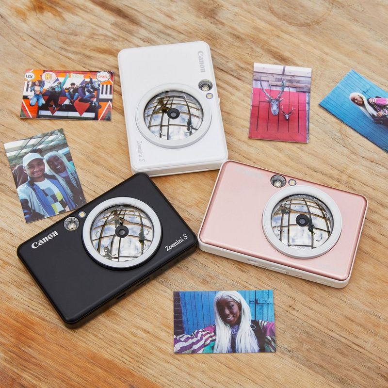 Canon Zoemini S Sofortbildkamera und Mini-Fotodrucker, Roségold Dreiecksanordnung eines Druckers mit Ausdrucken auf dem Schreibtisch