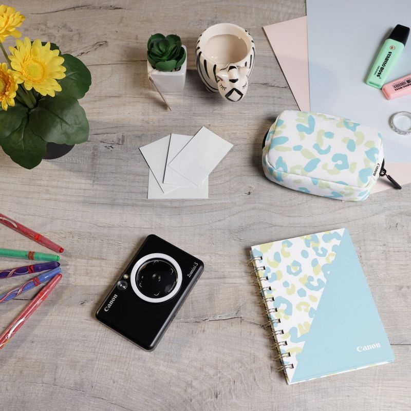 Canon Zoemini S mobile Sofortbildkamera mit Mini-Fotodrucker, Mattschwarz + Tagebuch + Tasche Drucker auf einem Schreibtisch mit Stiften