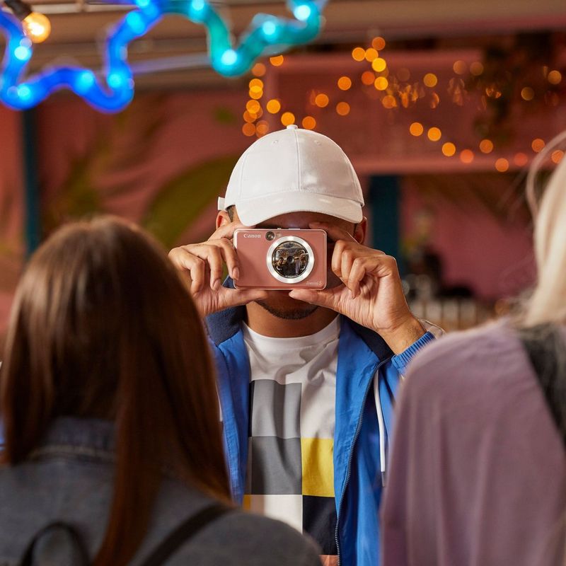 Canon Zoemini S mobile Sofortbildkamera mit Mini-Fotodrucker, Roségold + Tagebuch + Tasche Mann mit Kappe, der ein Foto knipst