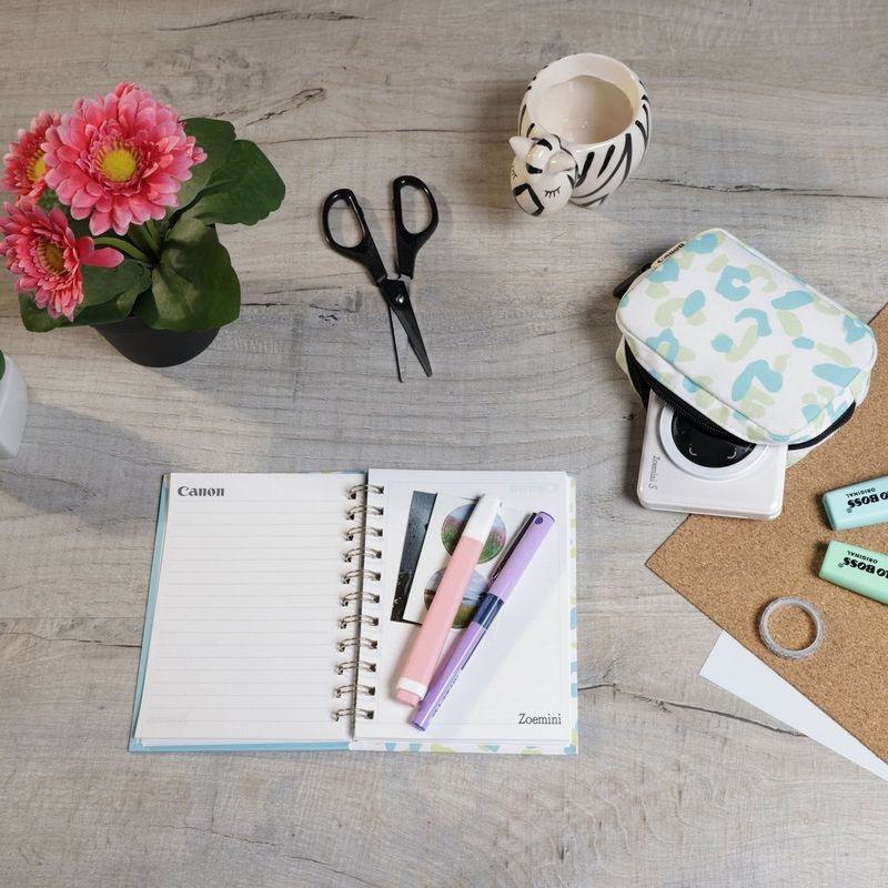 Canon Zoemini S mobile Sofortbildkamera mit Mini-Fotodrucker, Perlweiß + Tagebuch + Tasche Drucker auf einem Schreibtisch mit Scheren