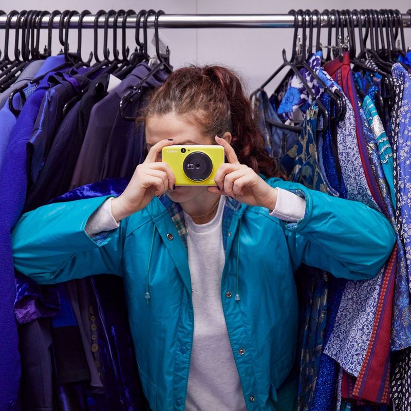 Canon Zoemini C Sofortbildkamera und Mini-Fotodrucker, Bumblebee Gelb Frauen, die ein Foto knipsen, mit einem Schrank im Hintergrund