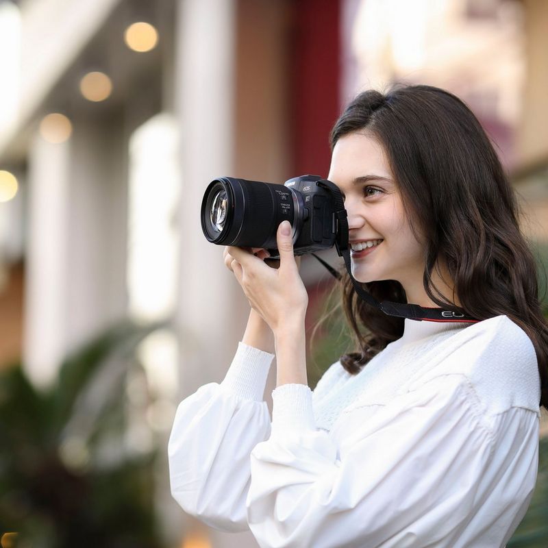 Canon RF 24-105mm F4-7.1 IS STM Objektiv Eine Frau, die eine Kamera vor ihr Gesicht hält
