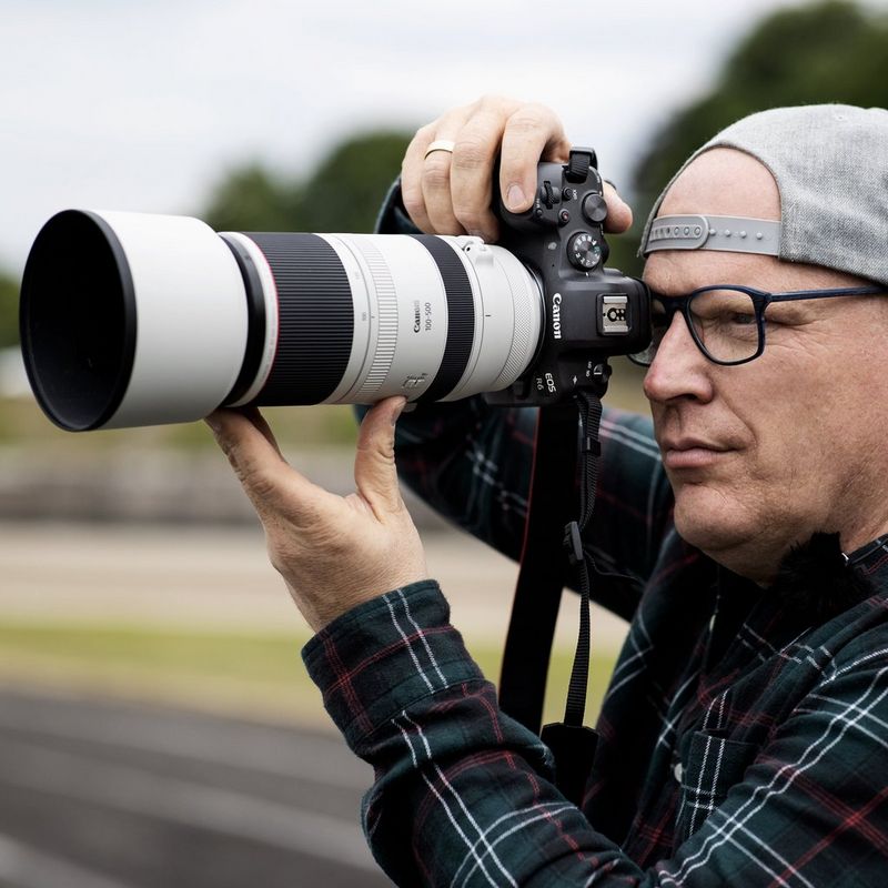 Canon RF 100-500mm F4.5-7.1L IS USM Objektiv Ein Mann, der eine Kamera vor sein Gesicht hält