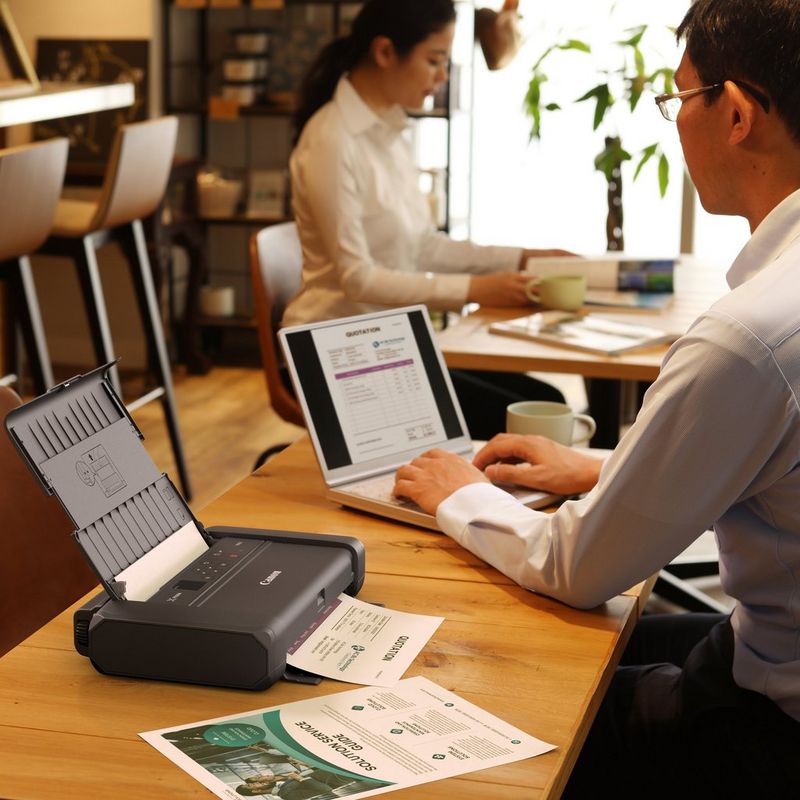 Canon LK-72 Battery Pack 0 Man working on a laptop besides the battery