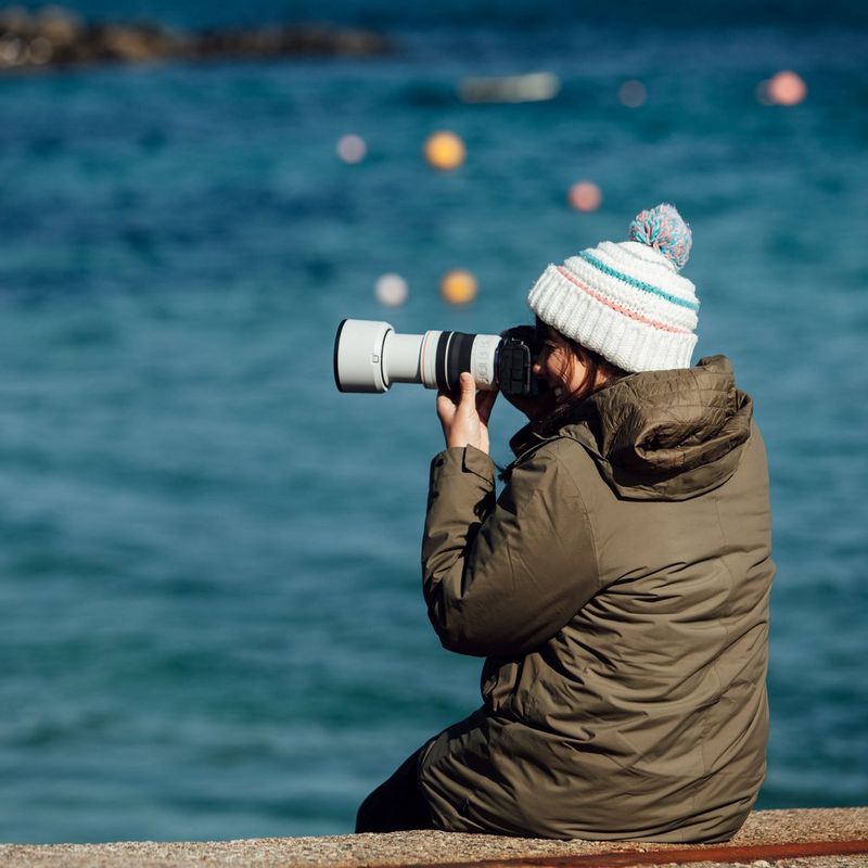 Canon RF 70-200mm F4L IS USM Objektiv Eine Frau, die eine Kamera vor ihr Gesicht hält