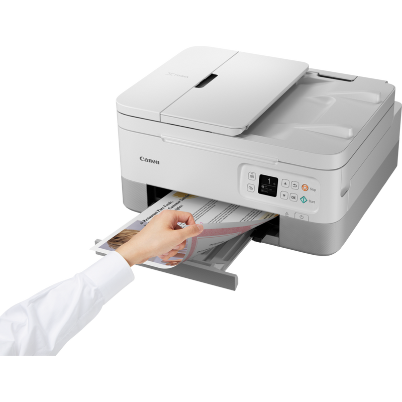 Canon PIXMA TS7451 Tintenstrahl-Multifunktionssystem, Weiß Produkt Schrägansicht von vorne mit einer Person, die das Foto aus dem Papierfach entnimmt