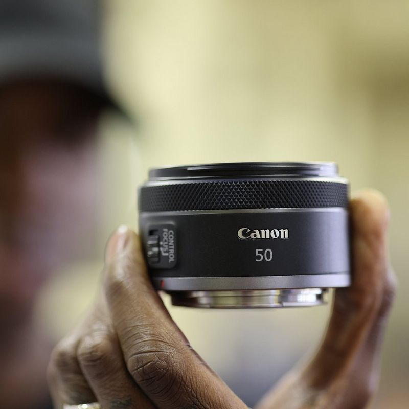 Canon RF 50mm F1.8 STM Objektiv Eine Hand, die das Objektiv hält