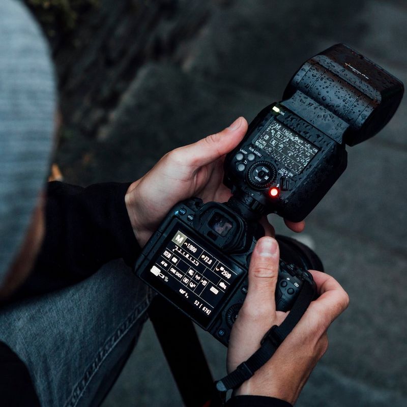 Canon Speedlite EL-1 Flash 0 Man Looking at the flash attached to a camera
