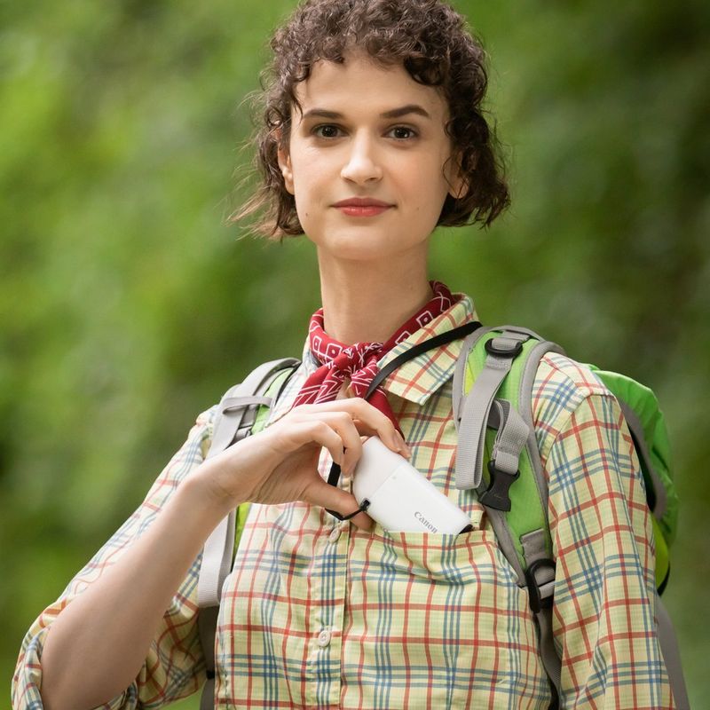 Canon PowerShot ZOOM Telephoto Monocular Compact Camera Essential Kit, Black Women keeping the camera in her pocket