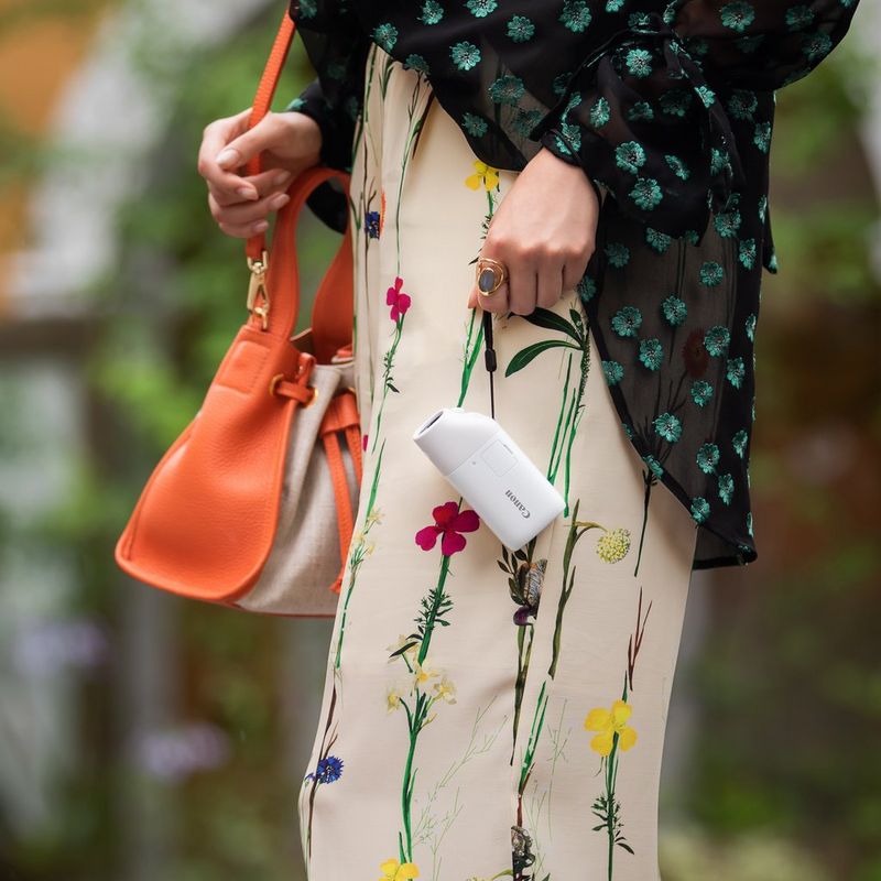 Canon PowerShot ZOOM Telephoto Monocular Compact Camera Essential Kit, Black Women holding the camera by its strap