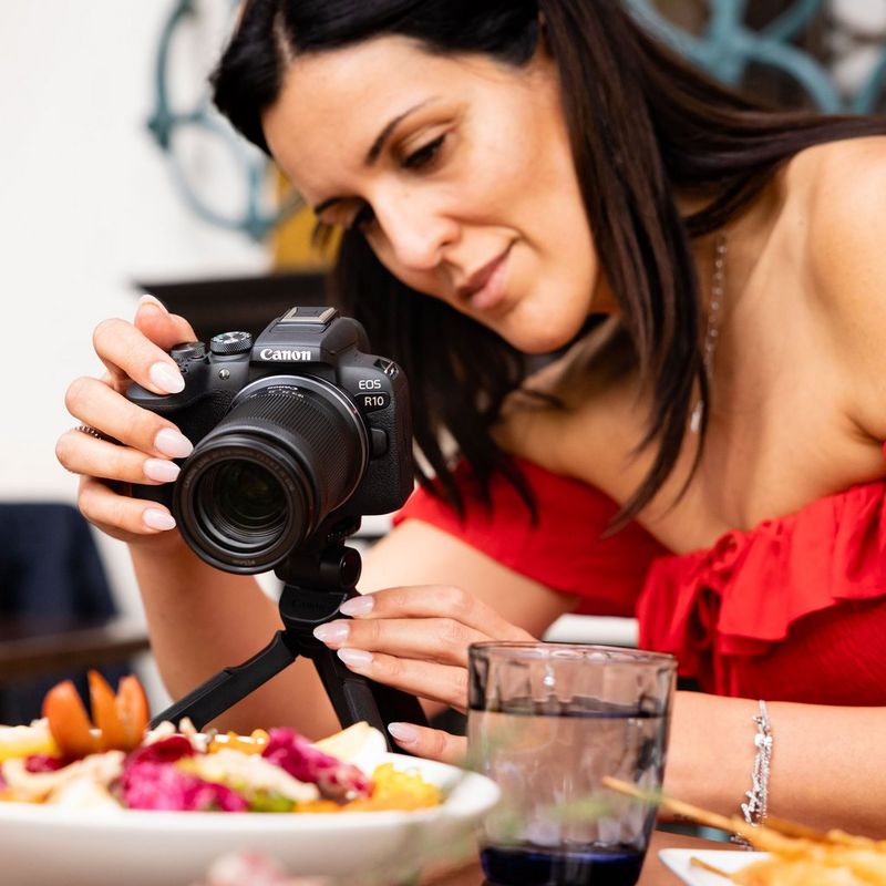 Canon EOS R10 spiegellose Kamera und RF-S 18-150mm F3.5-6.3 IS STM Objektiv Lifestyle Frau beim Fotografieren