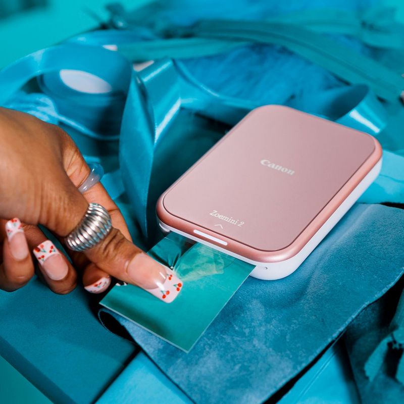 Canon Zoemini 2 mobiler Farb-Fotodrucker, Roségold Frau nimmt einen Druck aus dem Produkt heraus