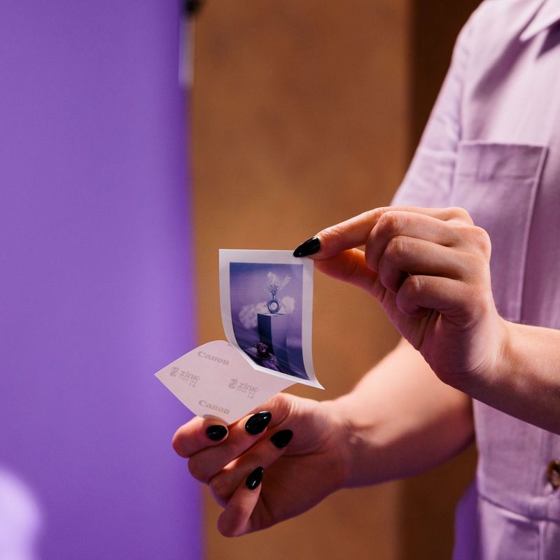 Canon Zoemini 2 mobiler Farb-Fotodrucker, Roségold Frau entfernt den rückseitigen Sticker von einem Foto