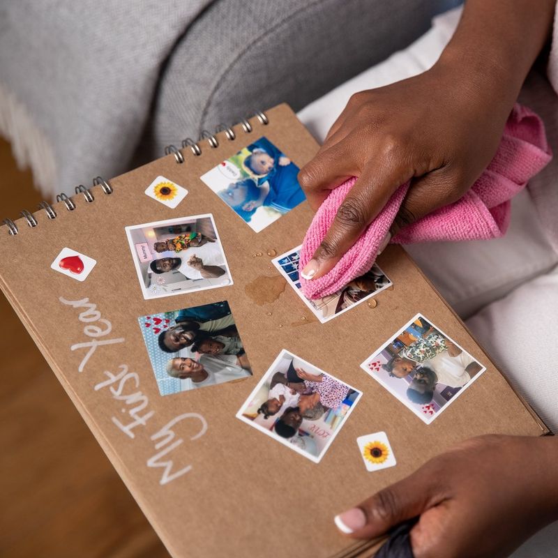 Fotos, die in ein Album geklebt werden, und rosa Stoff