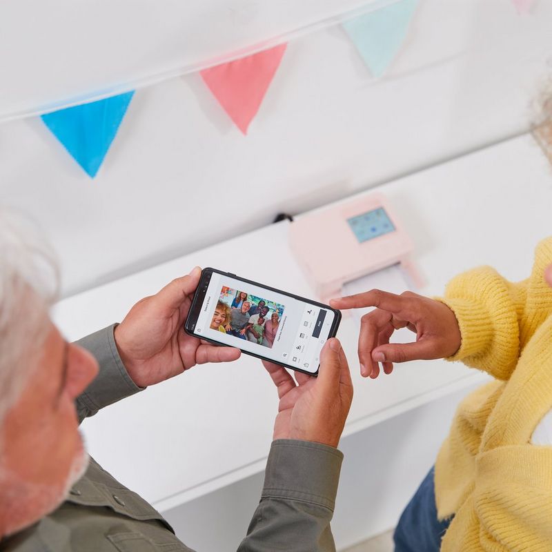 2 Personen, die das Produkt mit einem Mobiltelefon bedienen