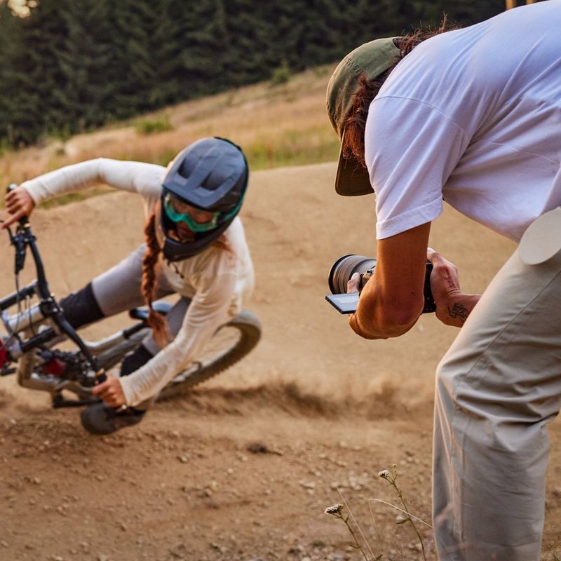 Canon EOS R6 Mark II spiegellose Kamera, Schwarz + Rucksack + SD-Karte+ Ersatzakku Ein Mann, der einen Fahrradfahrer mit einer Kamera mit ausgeklapptem Bildschirm filmt