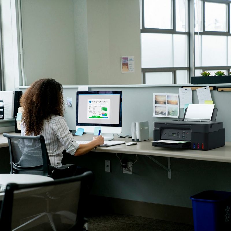 Canon PIXMA G2570 3-in-1 MegaTank Farbdrucker mit nachfüllbaren Tintenbehältern Produkt auf einem Schreibtisch, an dem ein Mann telefoniert