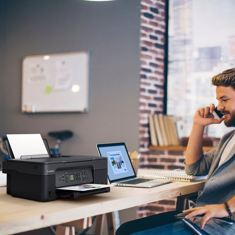 Canon PIXMA G3570 WLAN 3-in-1 MegaTank Farb-Multifunktionssystem mit nachfüllbaren Tintentanks , Schwarz Produkt auf einem Schreibtisch, an dem ein Mann telefoniert