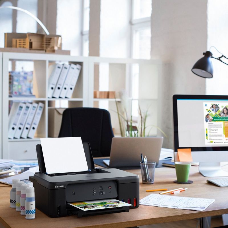 Canon PIXMA G1530 MegaTank Farbdrucker mit nachfüllbaren Tintenbehältern Produkt auf einem Schreibtisch mit Tintenflaschen