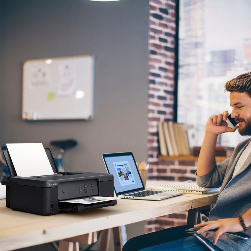 Canon PIXMA G1530 MegaTank Farbdrucker mit nachfüllbaren Tintenbehältern Produkt auf einem Schreibtisch, an dem ein Mann telefoniert