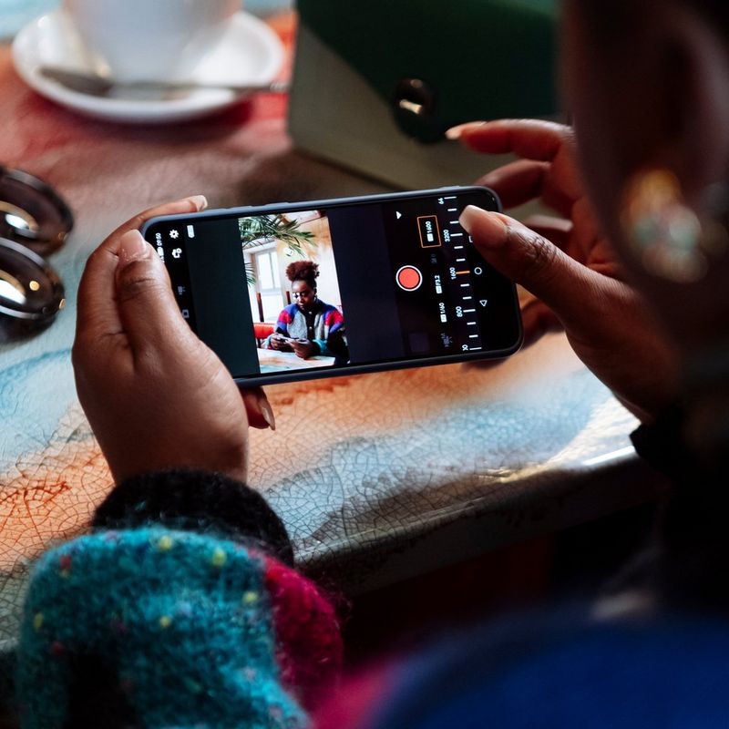 Canon EOS R50 spiegelloses Kameragehäuse, Schwarz Person mit Telefon