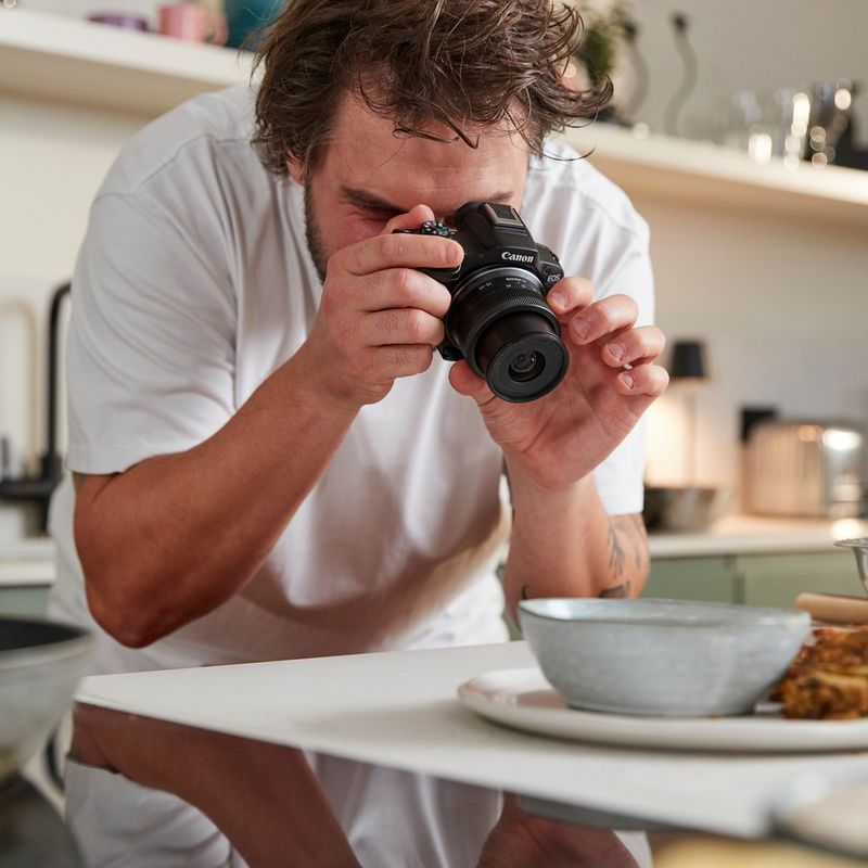 Canon EOS R50 spiegelloses Kameragehäuse, Schwarz Mann fotografiert eine Mahlzeit