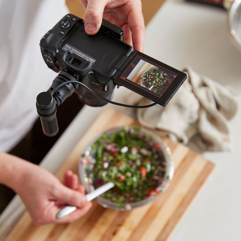 Canon EOS R50 spiegelloses Kameragehäuse Schwarz Vlogger Kit Mann fotografiert eine Mahlzeit