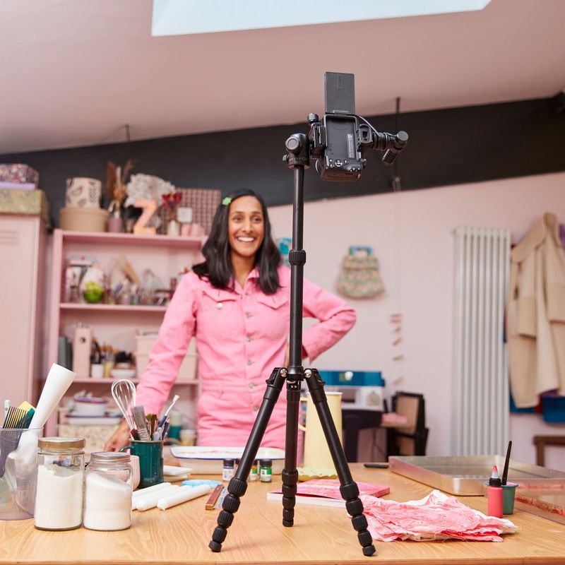 Canon EOS R50 spiegelloses Kameragehäuse Schwarz Vlogger Kit Frauen machen Aufnahmen mit dem Produkt, das auf einem Stativ platziert ist