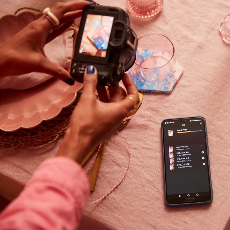 Canon EOS R50 spiegellose Kamera, Schwarz + RF-S 18-45mm F4.5-6.3 IS STM + Rucksack + SD-Karte + Ersatzakku Frauen fotografieren ein Glas mit einem Telefon daneben